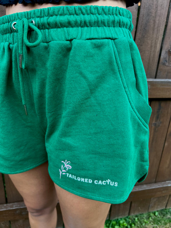 Tailored cactus girl in green matching shorts and sweat jacket with pink floral detail