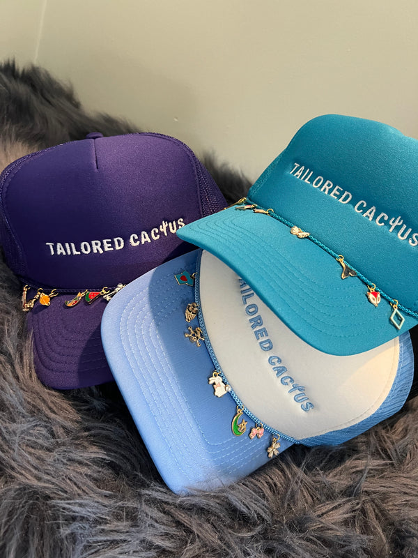 Tailored cactus hats in a pile with charms 