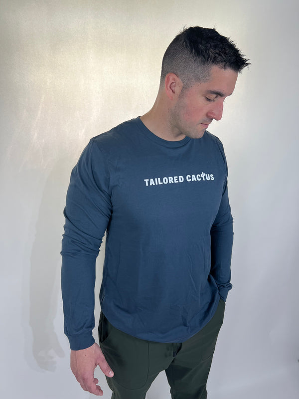 Tailored cactus man in blue long sleeve with saying ordinary people can do extraordinary things on back 