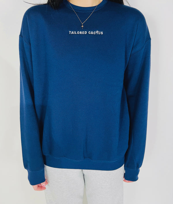 Tailored Cactus on front of navy blue crewneck sweatshirt 