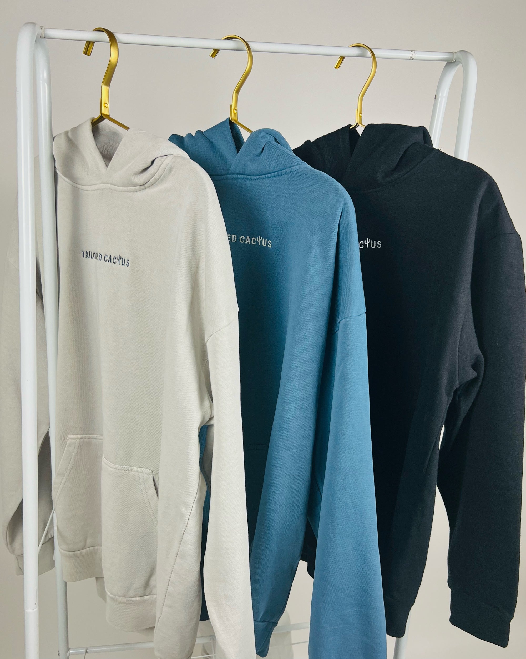 Row of tailored cactus hoodies on white, blue, and black 