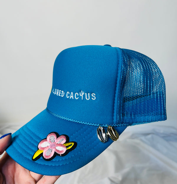 Tailored cactus blue trucker hat with seashell charms and pink flower 