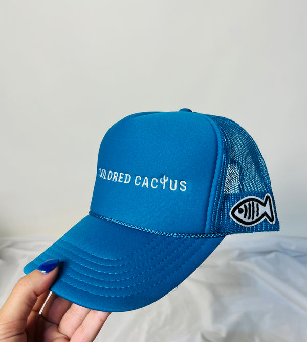 Tailored cactus blue trucker hat with white fish patch 