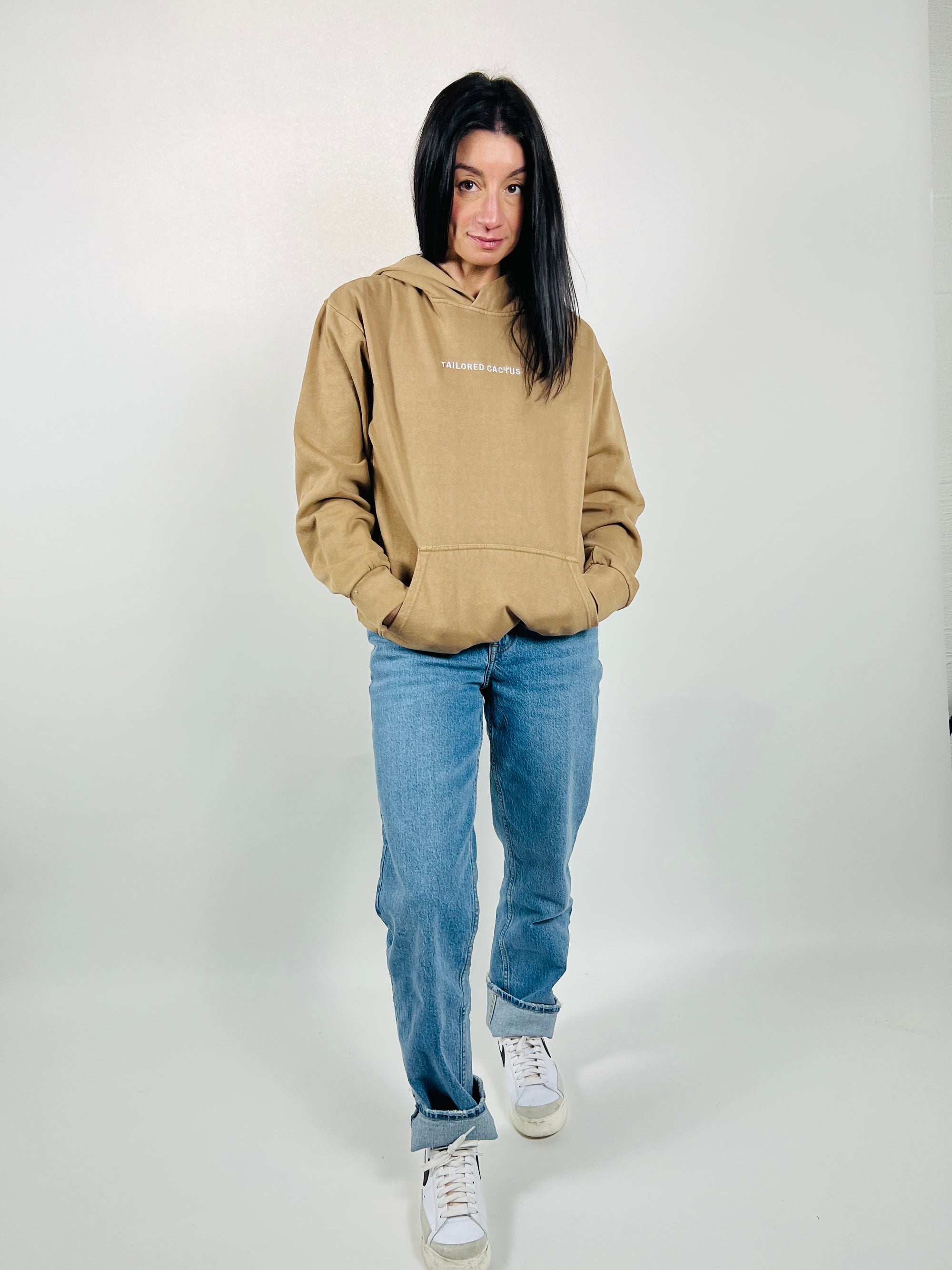 Girl wearing tan hoodie with tailored cactus font on the front 