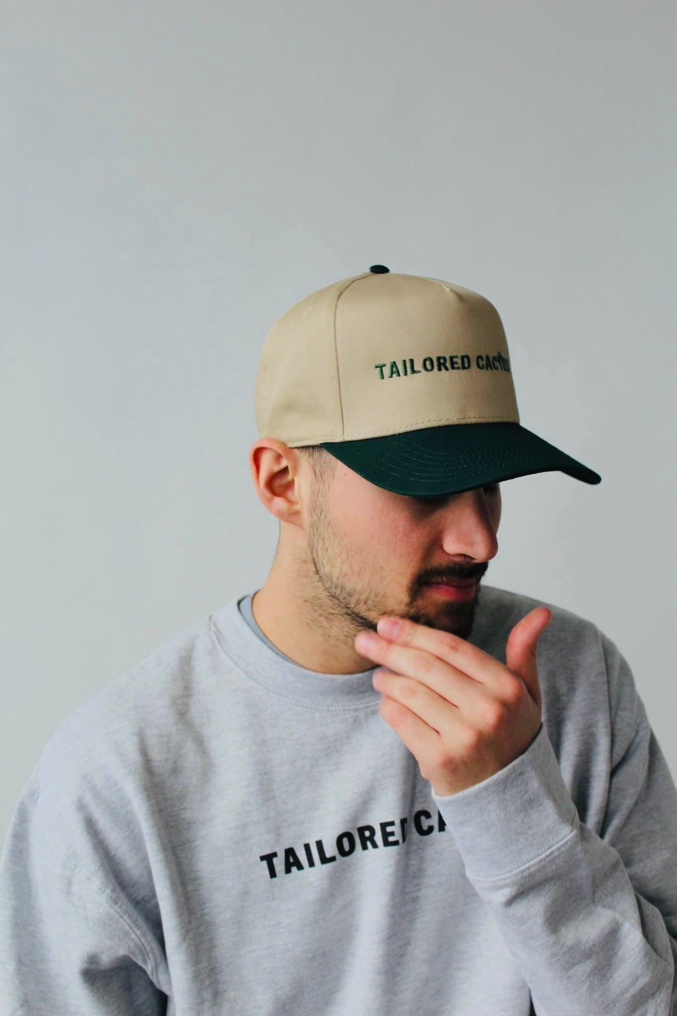 Tailored Cactus man wearing crewneck shirt with tan and green trucker hat